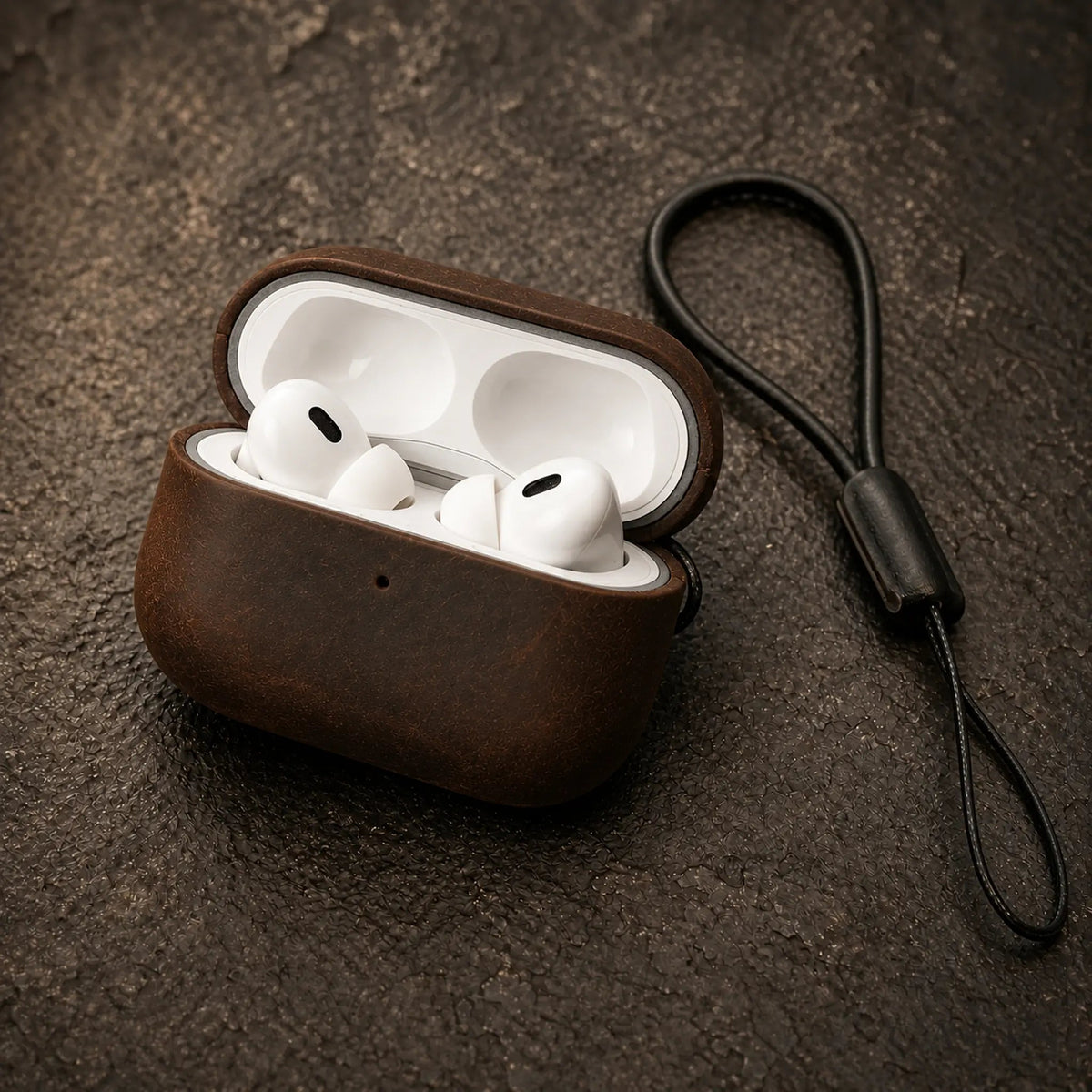 Ferrara Crazy Horse leather AirPods case open with AirPods Pro inside, on dark stone
