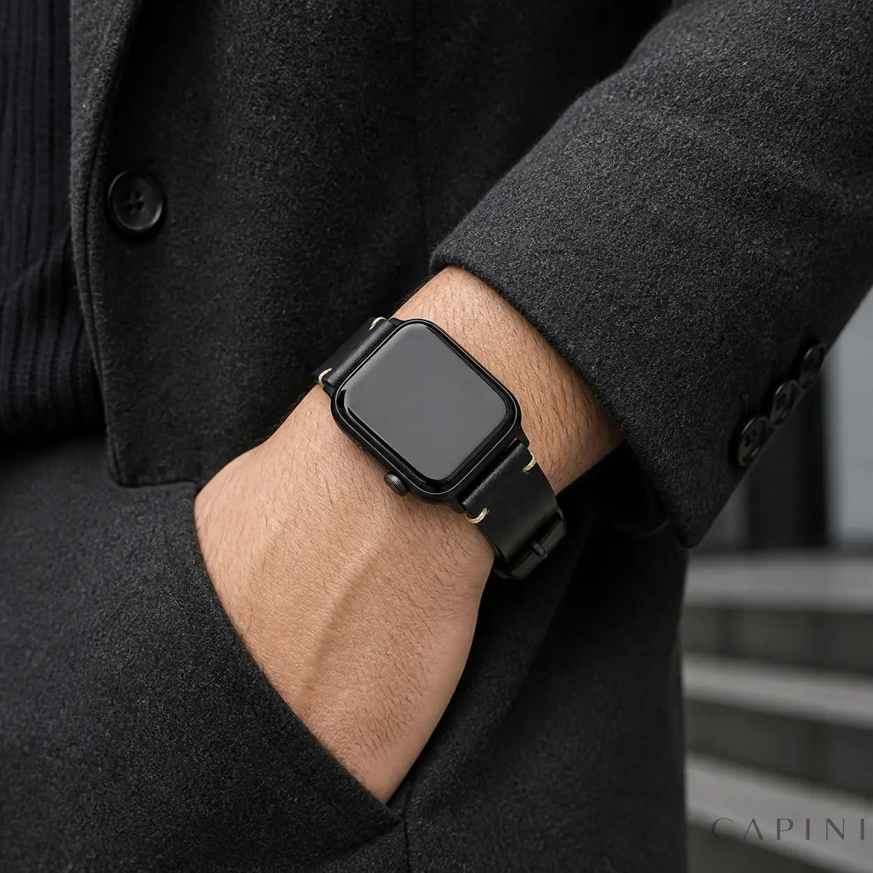 Black Trieste oil-wax Apple Watch strap with black hardware worn in an urban setting