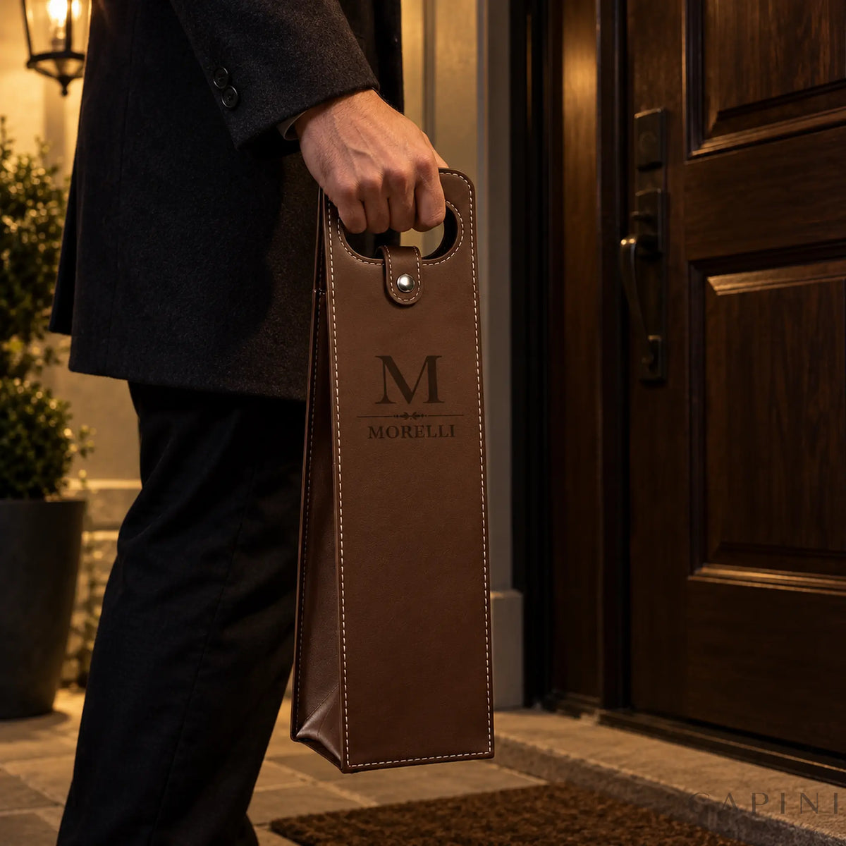 Male hand carrying a Conegliano Espresso wine carrier with Morelli monogram