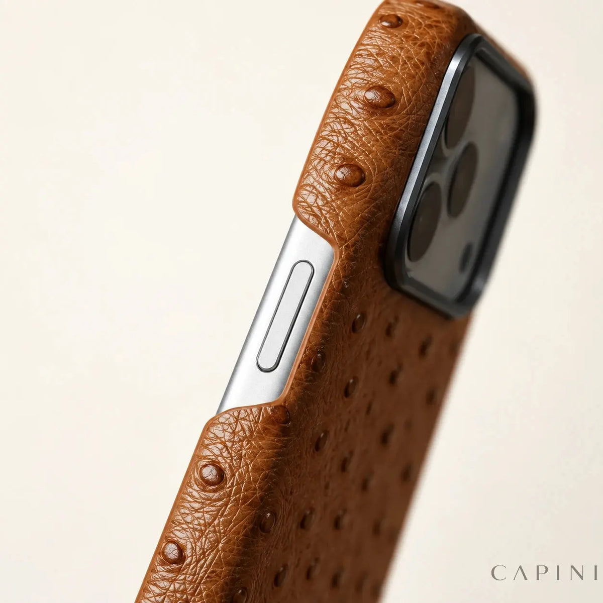 Deruta leather-wrapped edge and exposed phone side button; illustrative close-up.