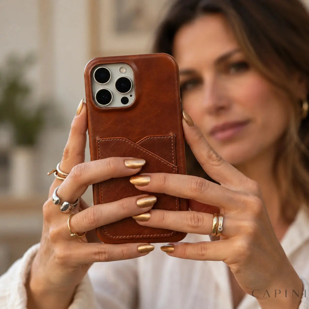 Treviso Chestnut leather case held for a selfie