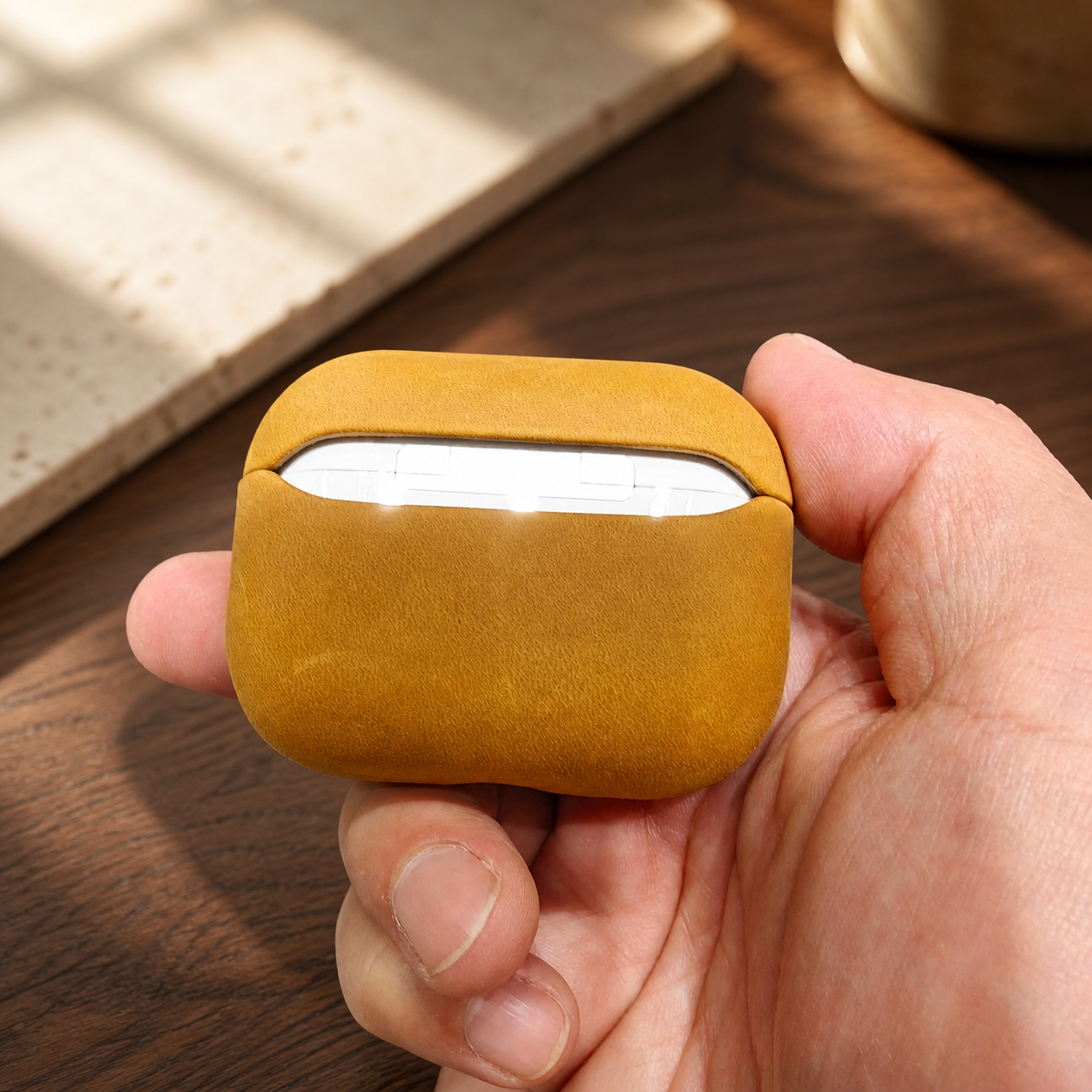 Orvieto leather AirPods case shown in hand for scale