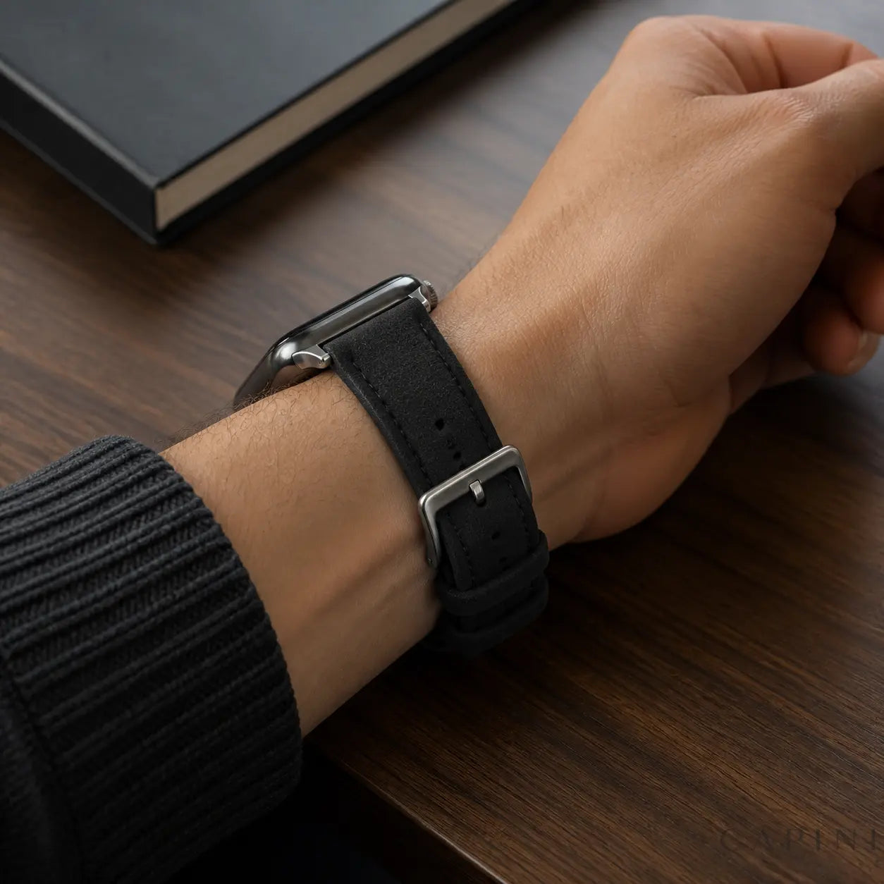 Black Monza Alcantara Apple Watch strap with silver buckle worn on the wrist