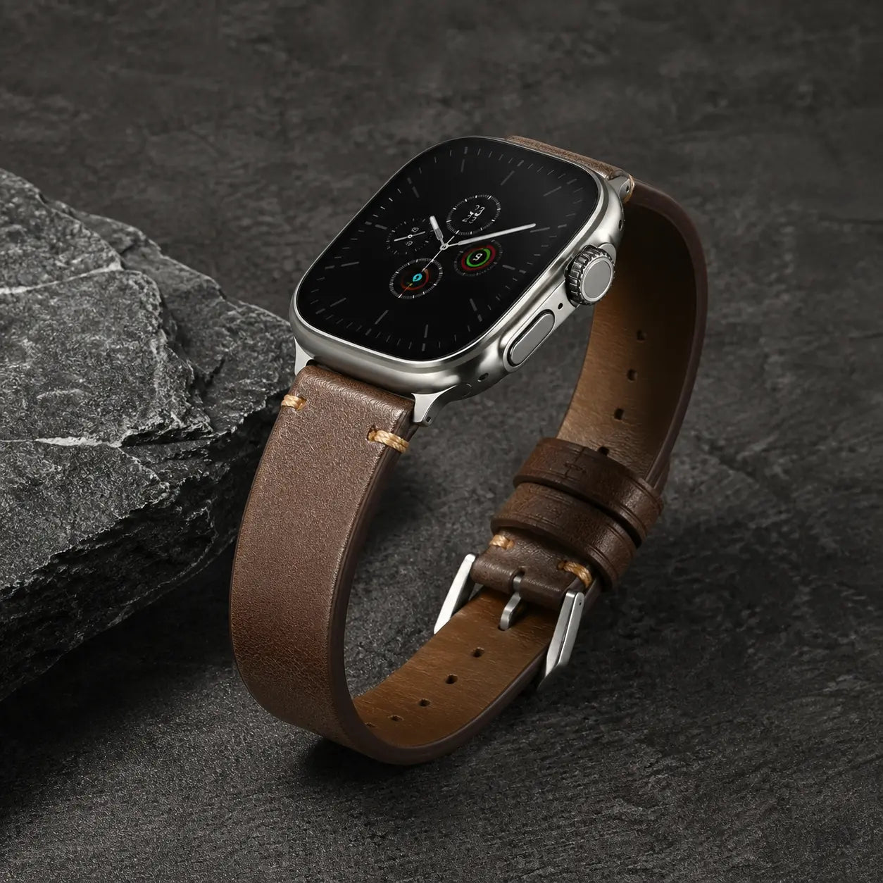 Brown Trieste oil-wax Apple Watch strap with silver hardware on dark stone