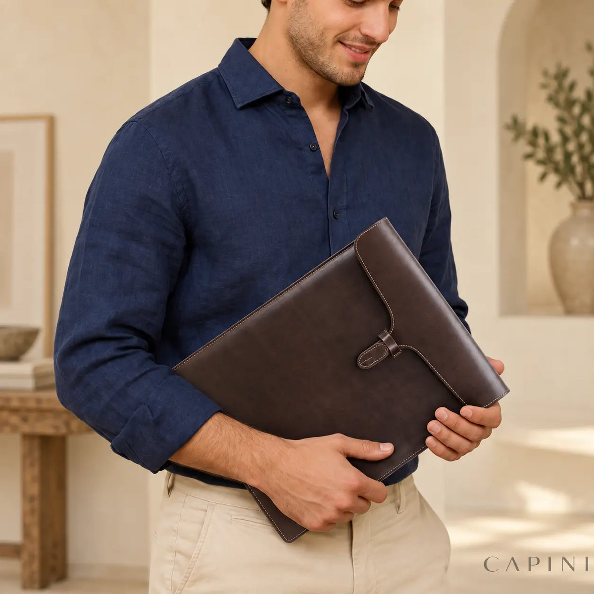 Solofra espresso leather envelope - closed sleeve carried in hands