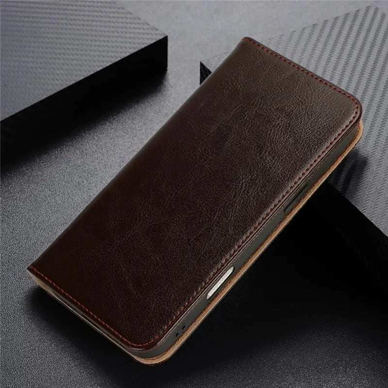 Genova cowhide flip case in Mocha Brown, closed, on dark leather