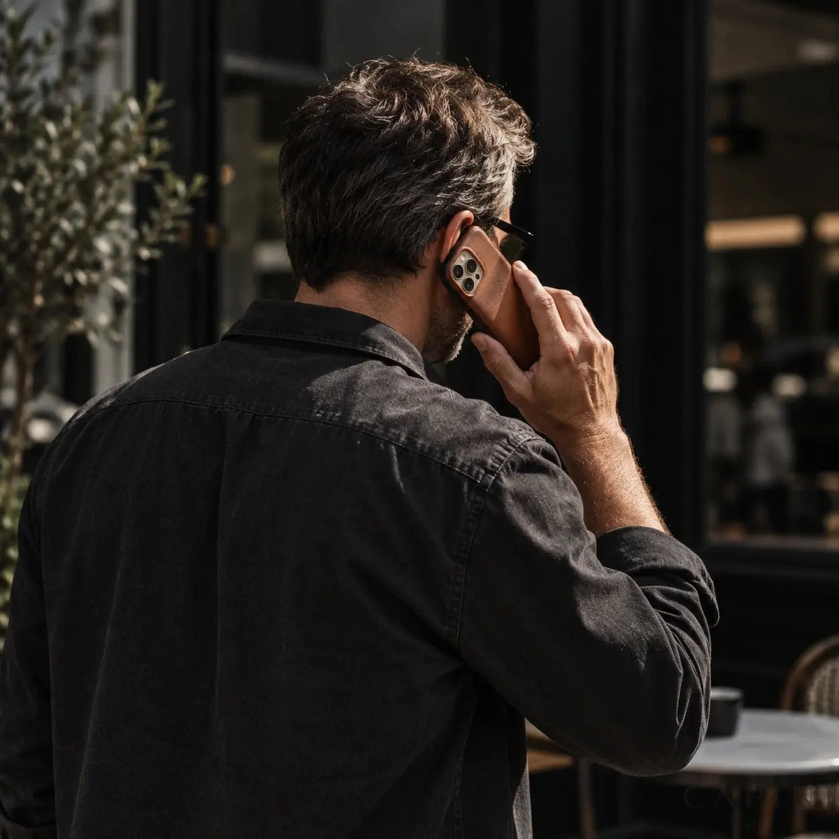 Copenhagen Espresso leather case in an outdoor phone-call scene