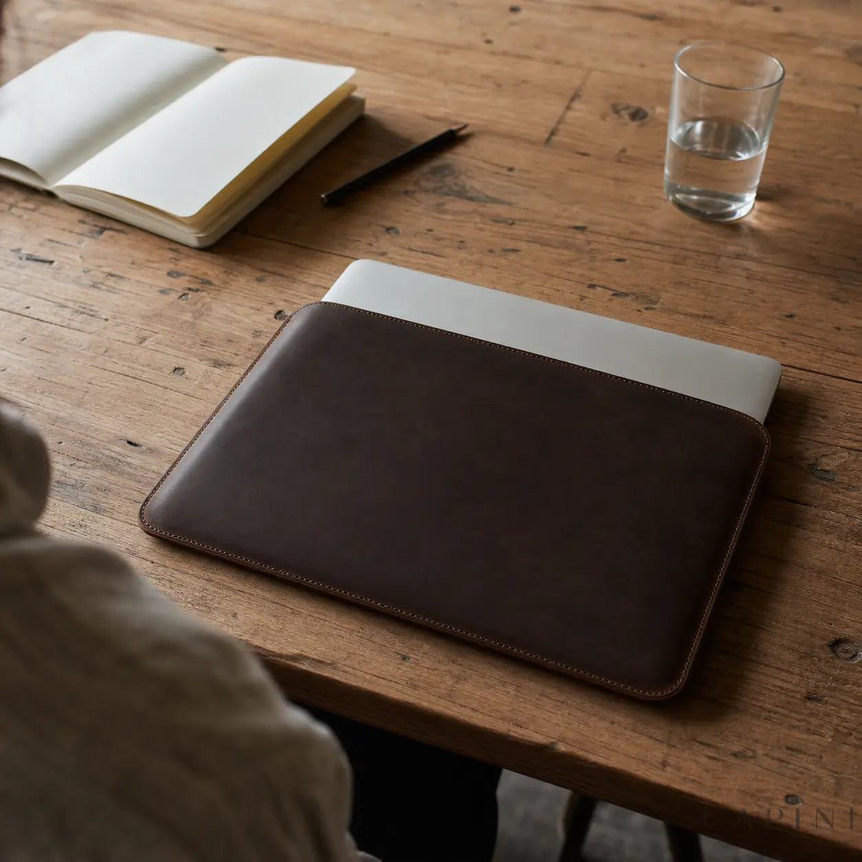 Ivrea Espresso leather MacBook sleeve on a worktable