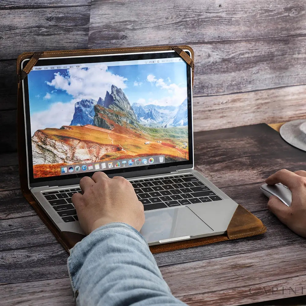 Fabriano Nubuck MacBook Folio open with a MacBook secured by leather corner retainers