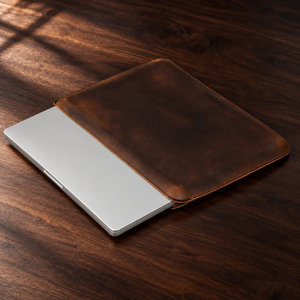 Pavia Espresso real-product view with closed laptop on dark walnut