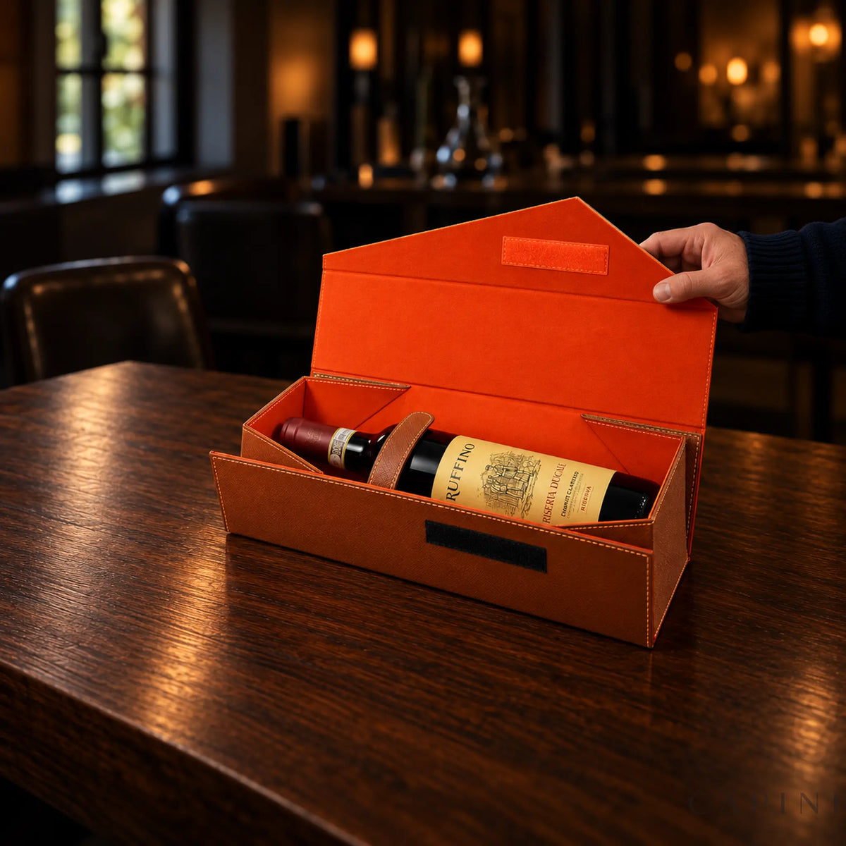 Male hand opening the Radda Cognac gift box with orange lining and Ruffino Riserva Ducale bottle