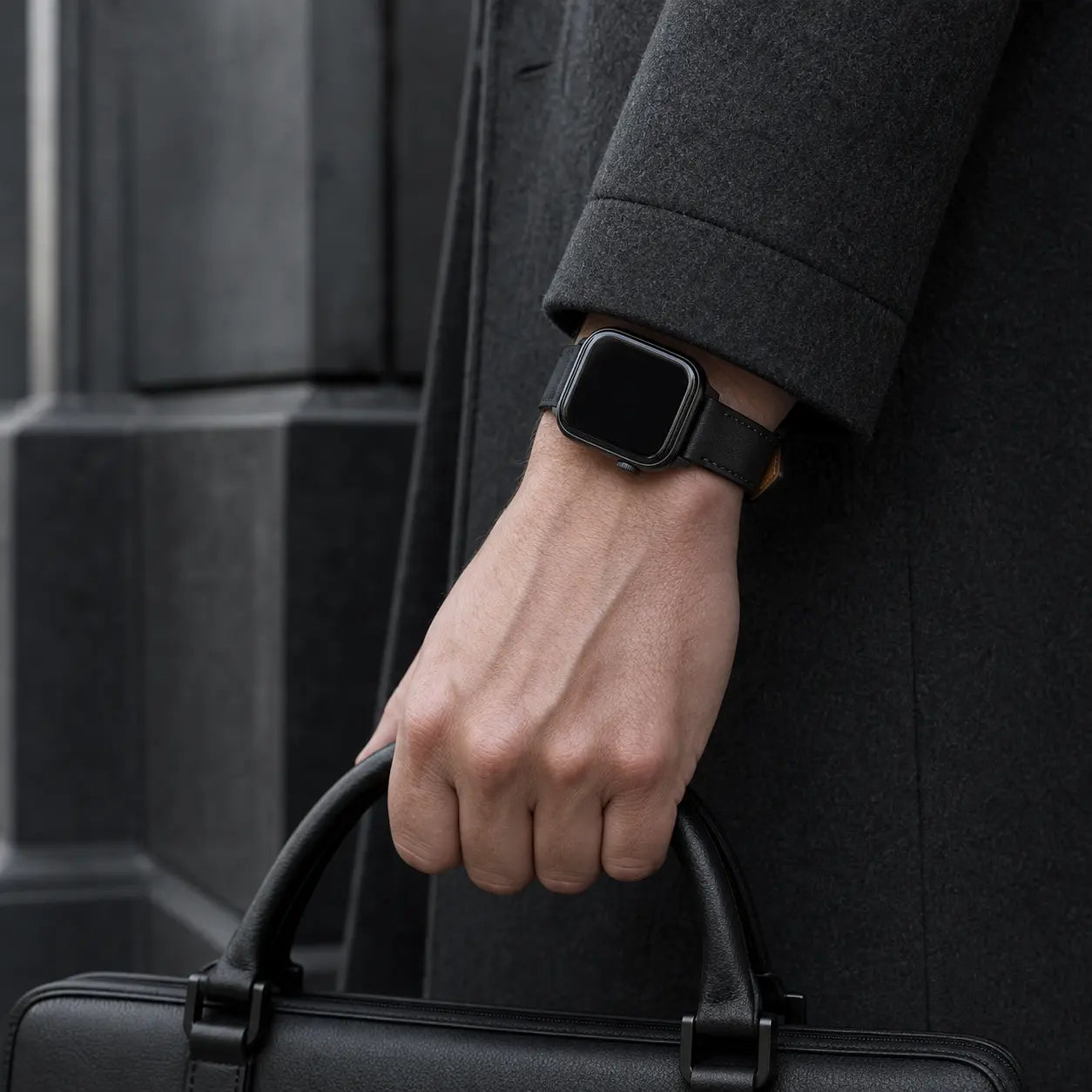 Black Terni Two-Tone Apple Watch strap with matte black hardware worn with a charcoal coat