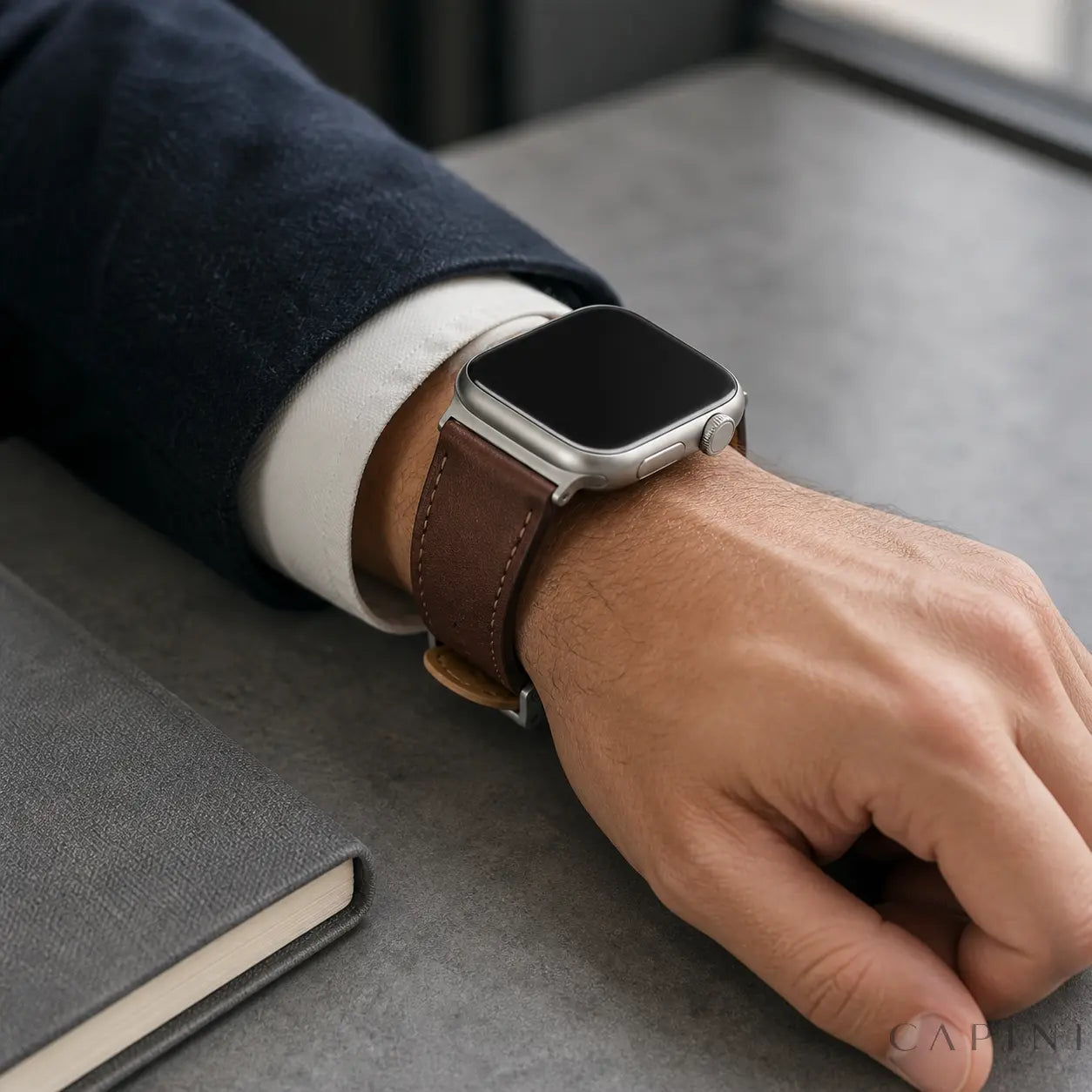 Dark brown Terni Two-Tone Apple Watch strap with titanium-tone hardware worn with a navy blazer